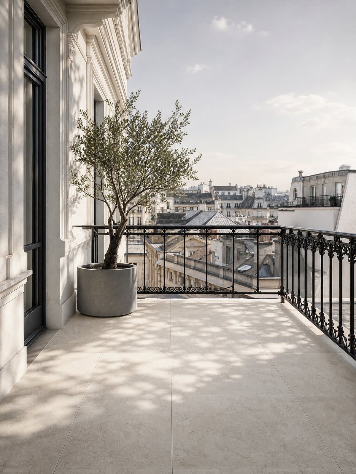 Altbau-Balkon in Wien mit hellen Bodenplatten und Schmiedeeisengeländer